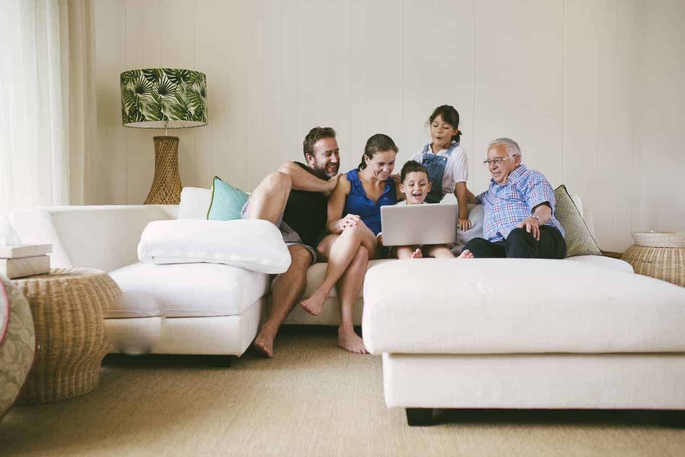Family looking at computer together on a modular sofa lounge